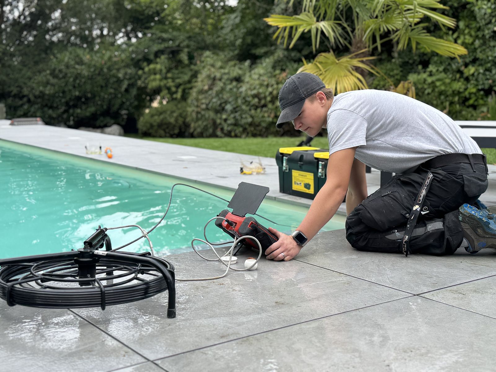 Technikerin bei der Leckagesuche mit Rohrkamera am Pool