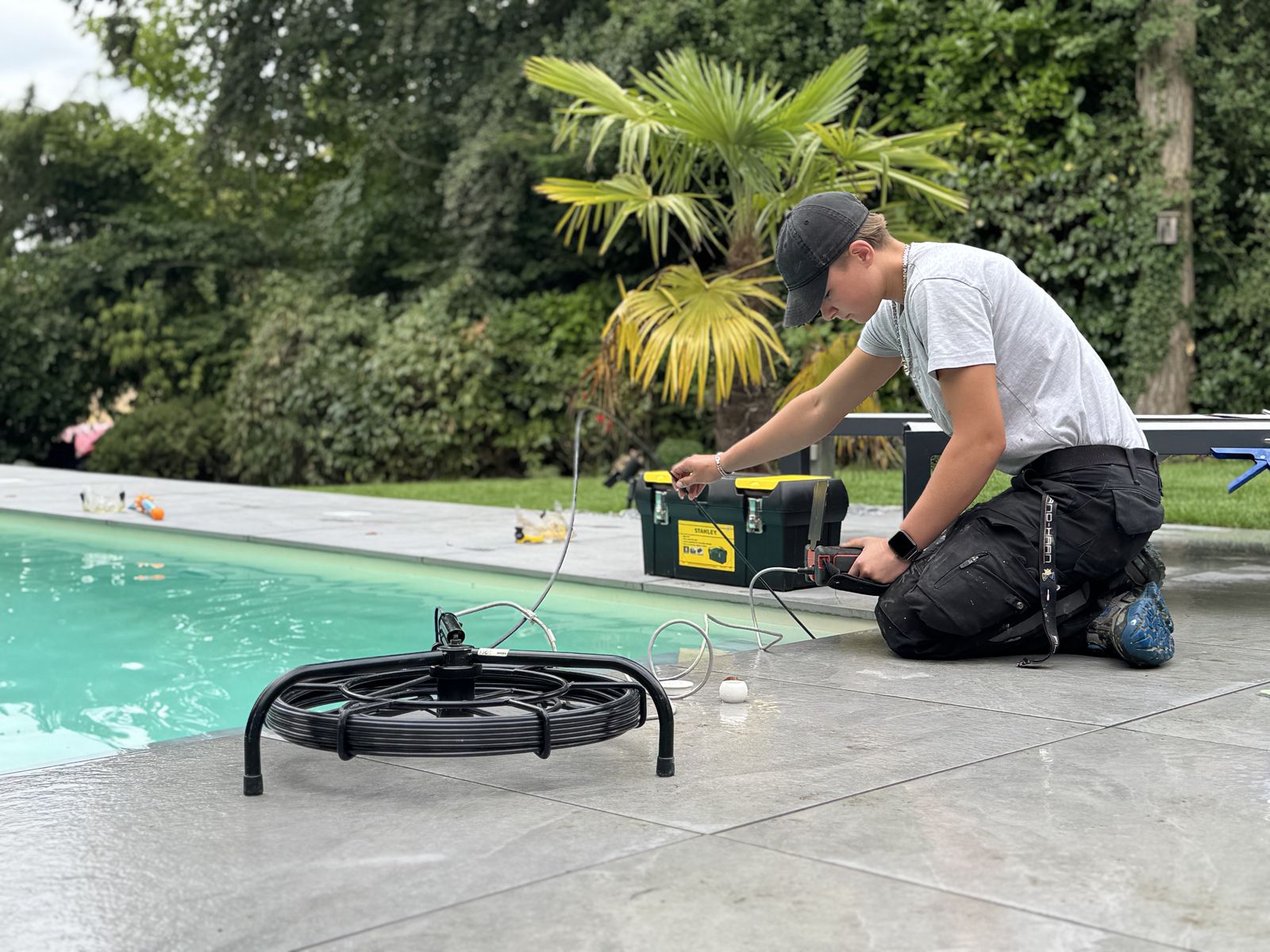 Technikerin sucht mit Rohrkamera ein Leck am Pool